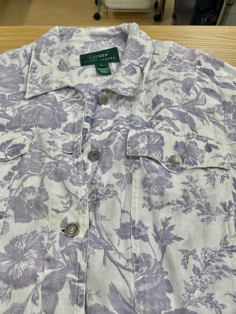 ローレンラルフローレンの白地に紫の花柄があしらわれたデニムジャケットの背面裾の革パッチからの色移りがキレイに落ちた染み抜きクリーニング事例（７，７００円税込、修理代も含む）2026.04.11
