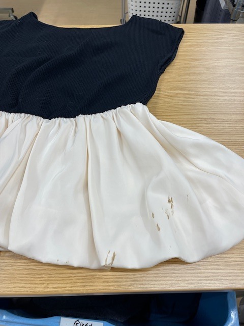 上半分が黒い面で下半分が白いレーヨンフレアになっているトップスの白い部分に付いたヘアカラーがキレイに落ちた染み抜きクリーニング事例(３，９６０円税込）2026.07.18