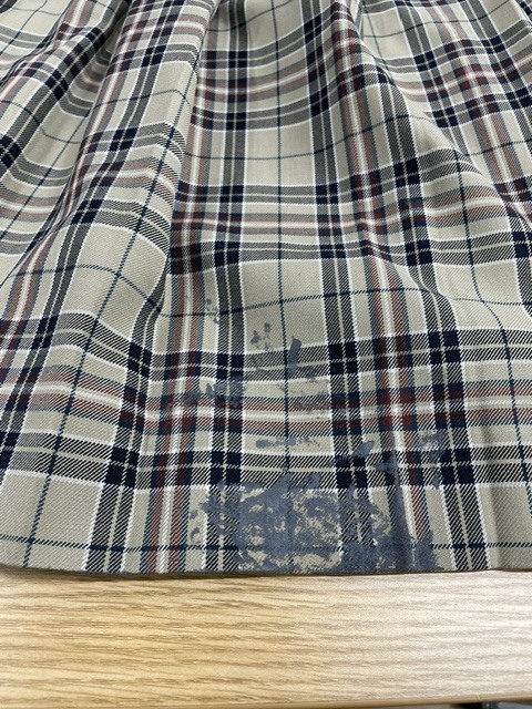 絵の具のシミが広範囲に付いたベージュチェック柄学生服スカートの染み抜きクリーニング事例(６，６００円税込)2026.09.30