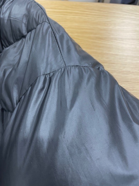 左肩から袖にかけてネイルグルーのシミが付いて固まってしまった黒いダウンジャケットの染み抜きクリーニング事例(７，７００円税込)2026.04.03