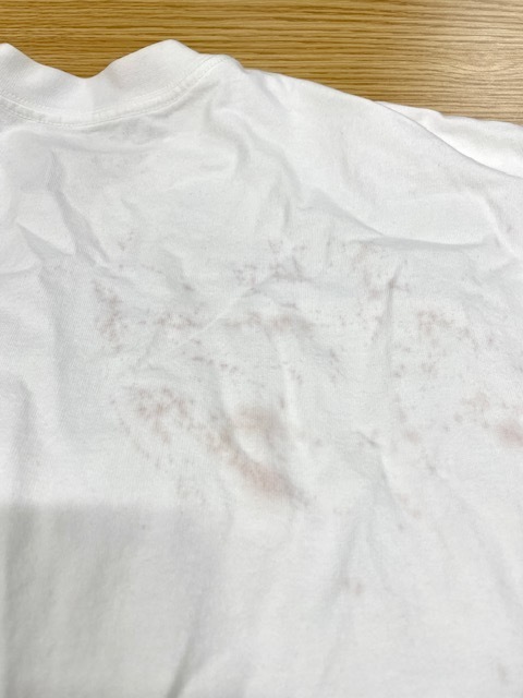 美容師様からの依頼で白いTシャツの背面に広範囲に付いた赤いヘアカラーシミの染み抜きクリーニング事例(５，５００円税込)2026.05.27