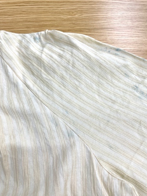 薄いベージュのインド綿シャツに青い色が移ってしまいそれを落とすためには全体の色も落とさなくてはならず色移りを落としつつ全体の色も平らに白くした染み抜きクリーニング事例（５，５００円税込）2026.06.07