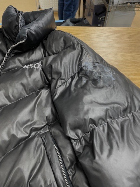 左肩から袖にかけてネイルグルーのシミが付いて固まってしまった黒いダウンジャケットの染み抜きクリーニング事例(７，７００円税込)2026.04.03