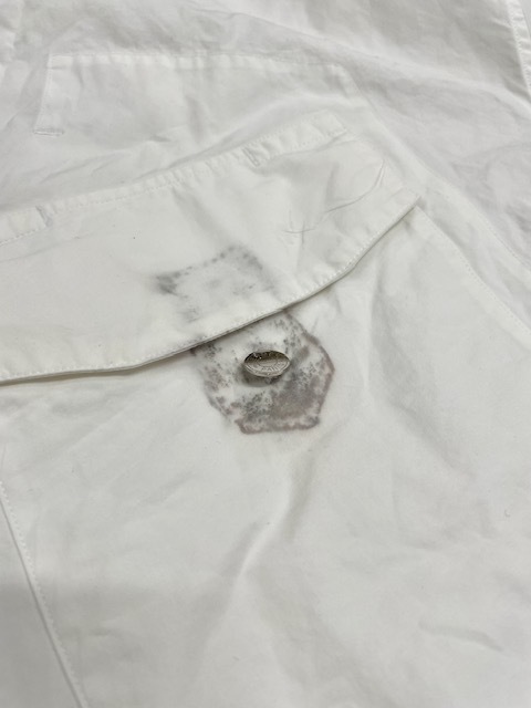 家庭洗濯時に左胸ポケットに付いていた取り外し可能な焦げ茶色の革を外し忘れそこから各所に濃く色滲みしてしまった白いエルメスコットンシャツ染み抜きクリーニング事例(５，５００円税込)2026.05.17