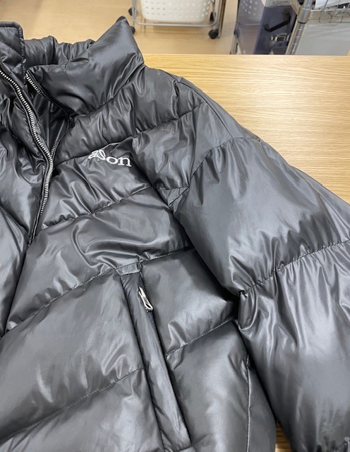 左肩から袖にかけてネイルグルーのシミが付いて固まってしまった黒いダウンジャケットの染み抜きクリーニング事例(７，７００円税込)2026.04.03