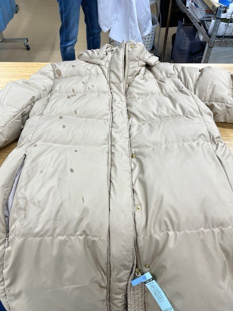 薄ベージュのダウンコート全体に付いたボンドやインクシミがキレイに落ちた染み抜きクリーニング事例（２２，０００円税込）2026.02.06