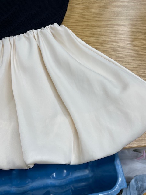 上半分が黒い面で下半分が白いレーヨンフレアになっているトップスの白い部分に付いたヘアカラーがキレイに落ちた染み抜きクリーニング事例(３，９６０円税込）2026.07.18
