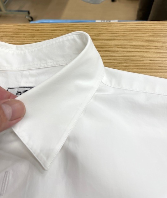 家庭洗濯時に左胸ポケットに付いていた取り外し可能な焦げ茶色の革を外し忘れそこから各所に濃く色滲みしてしまった白いエルメスコットンシャツ染み抜きクリーニング事例(５，５００円税込)2026.05.17
