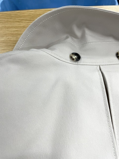 ヘアオイルのシミが襟周り肩の方まで黄ばんだように広がっているトレンチコートの染み抜きクリーニング事例(７，７００円税込）2026.10.02